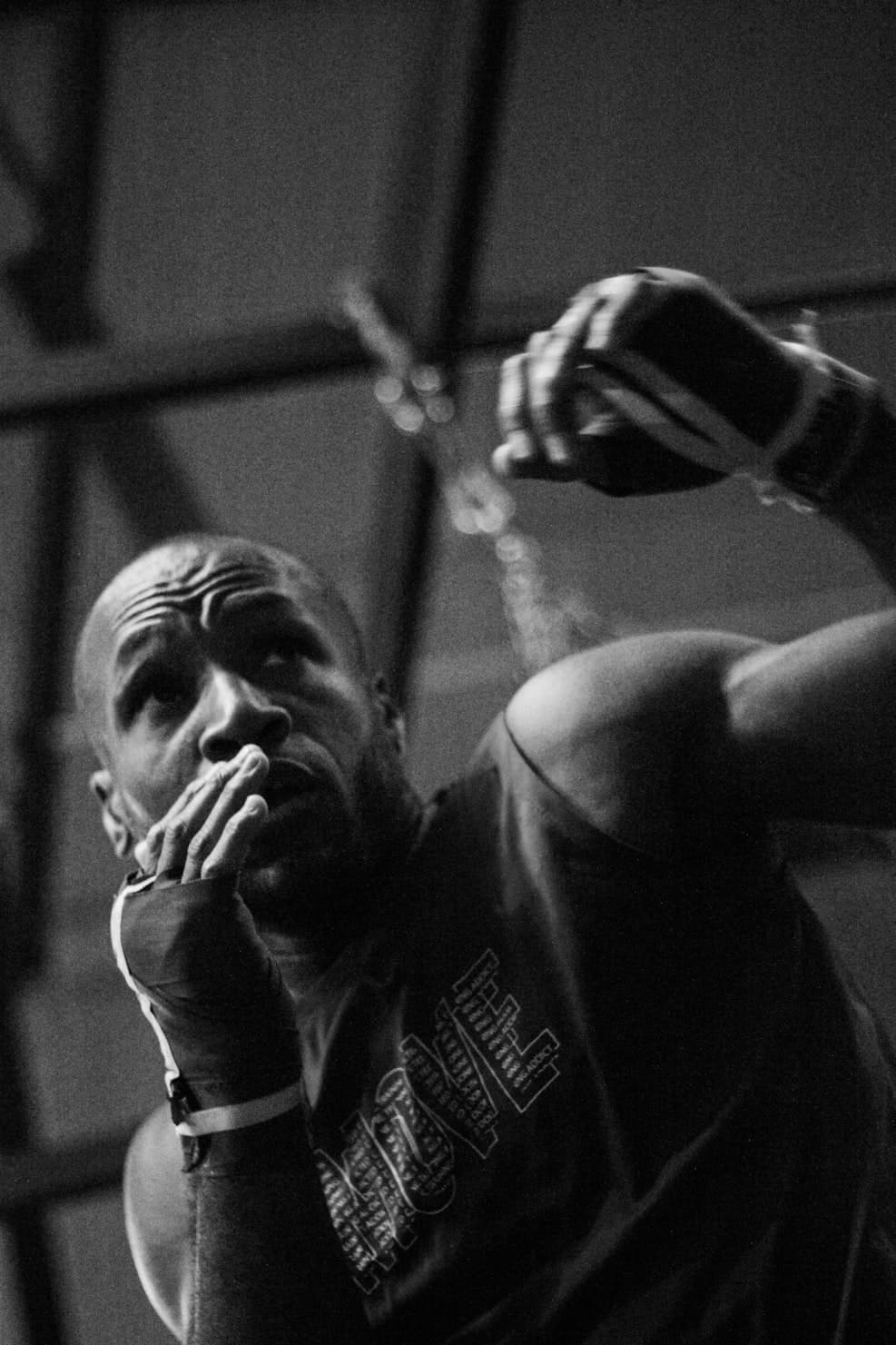 Boxer in hand wraps at the top of a jab, lead hand already back at the chin — the recovery Form Fighter times.