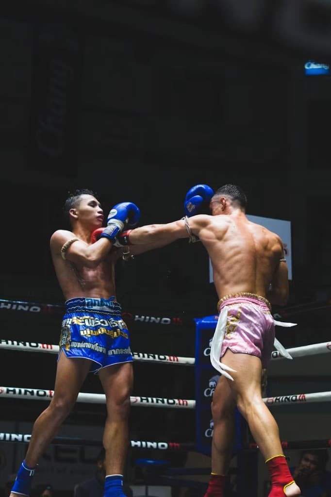 Muay Thai fighter landing a cross in the ring with the rear shoulder turned all the way through — the hips-before-hands timing Form Fighter checks.